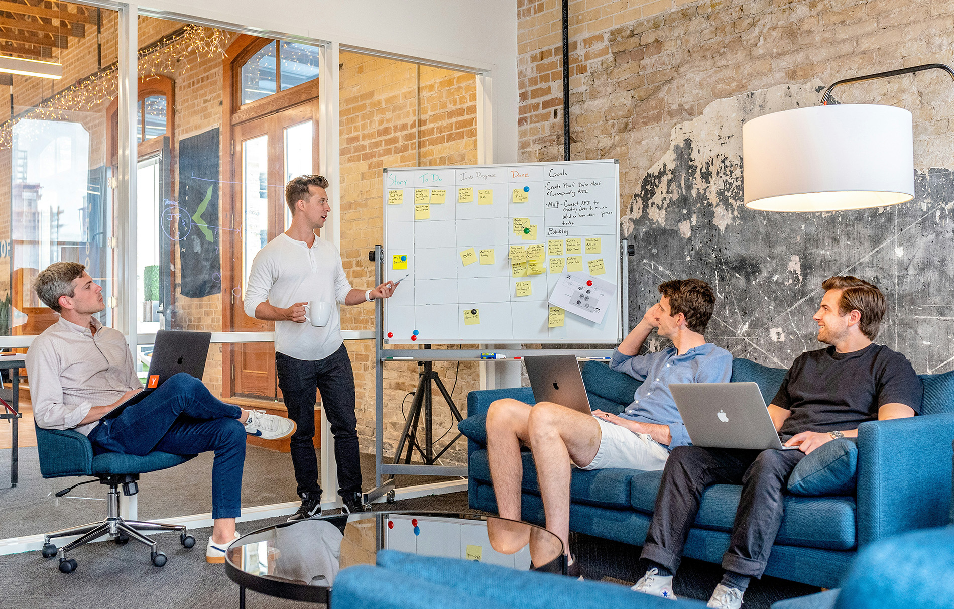 4 Männer sitzen in einem Büro zusammen und besprechen sich