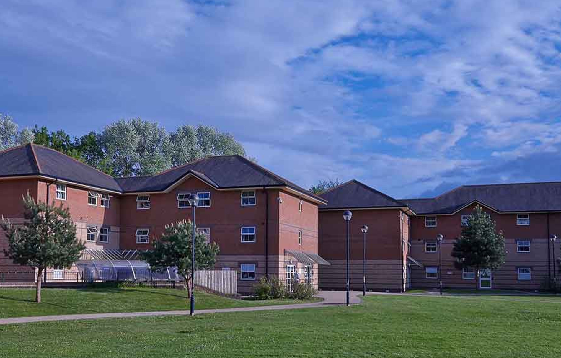 Schulgebäude von außen, darüber blauer Himmel