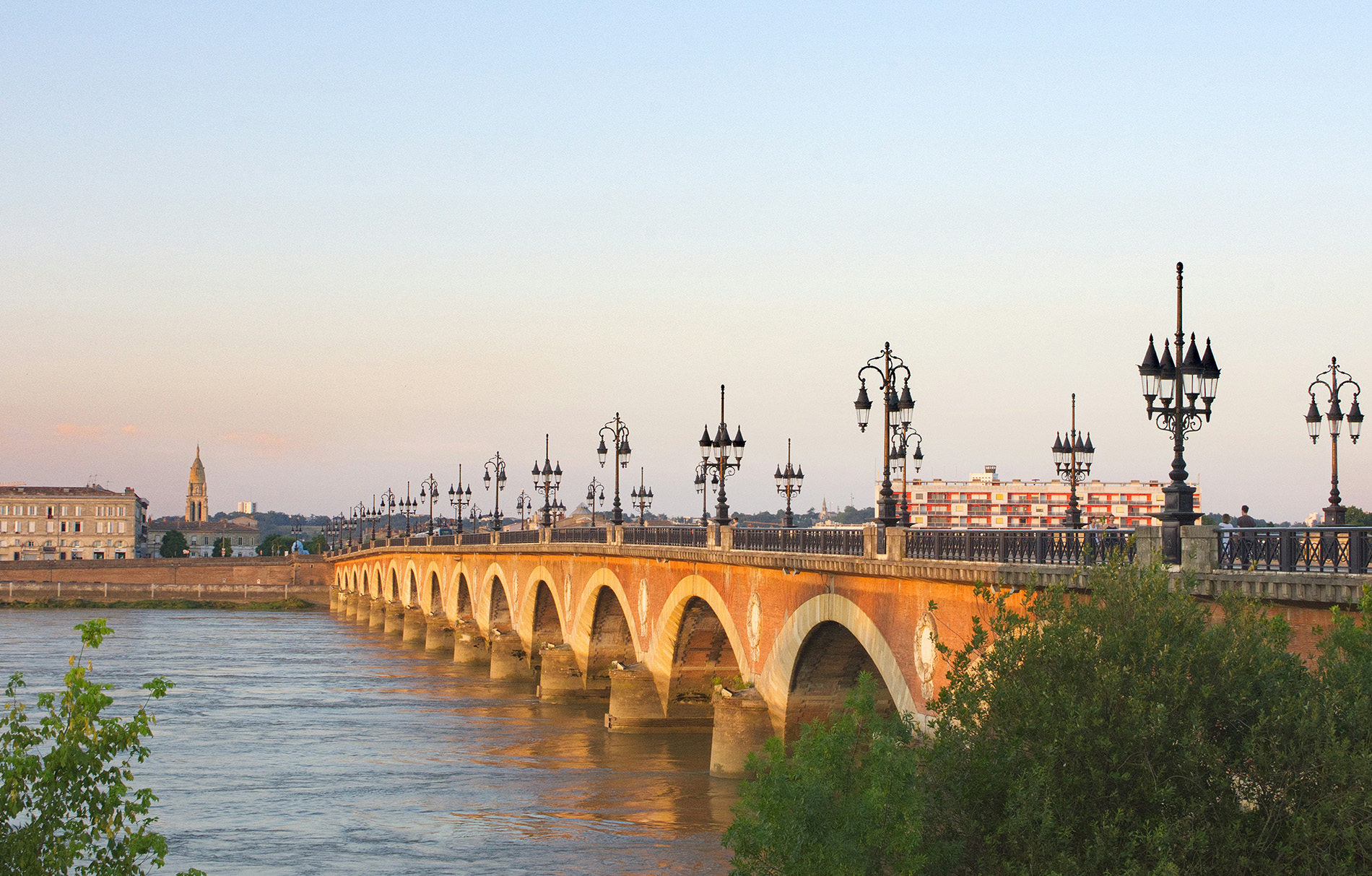 Geschwungene Brücke über französischen Fluss bei Sonnenuntergang