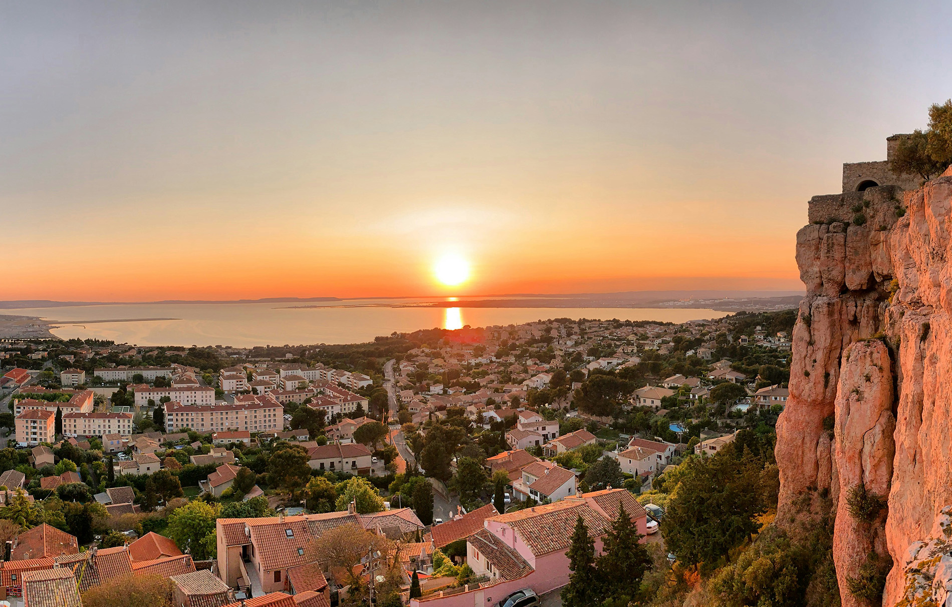 Blick auf eine französische Stadt am Wasser beim Sonnenuntergang