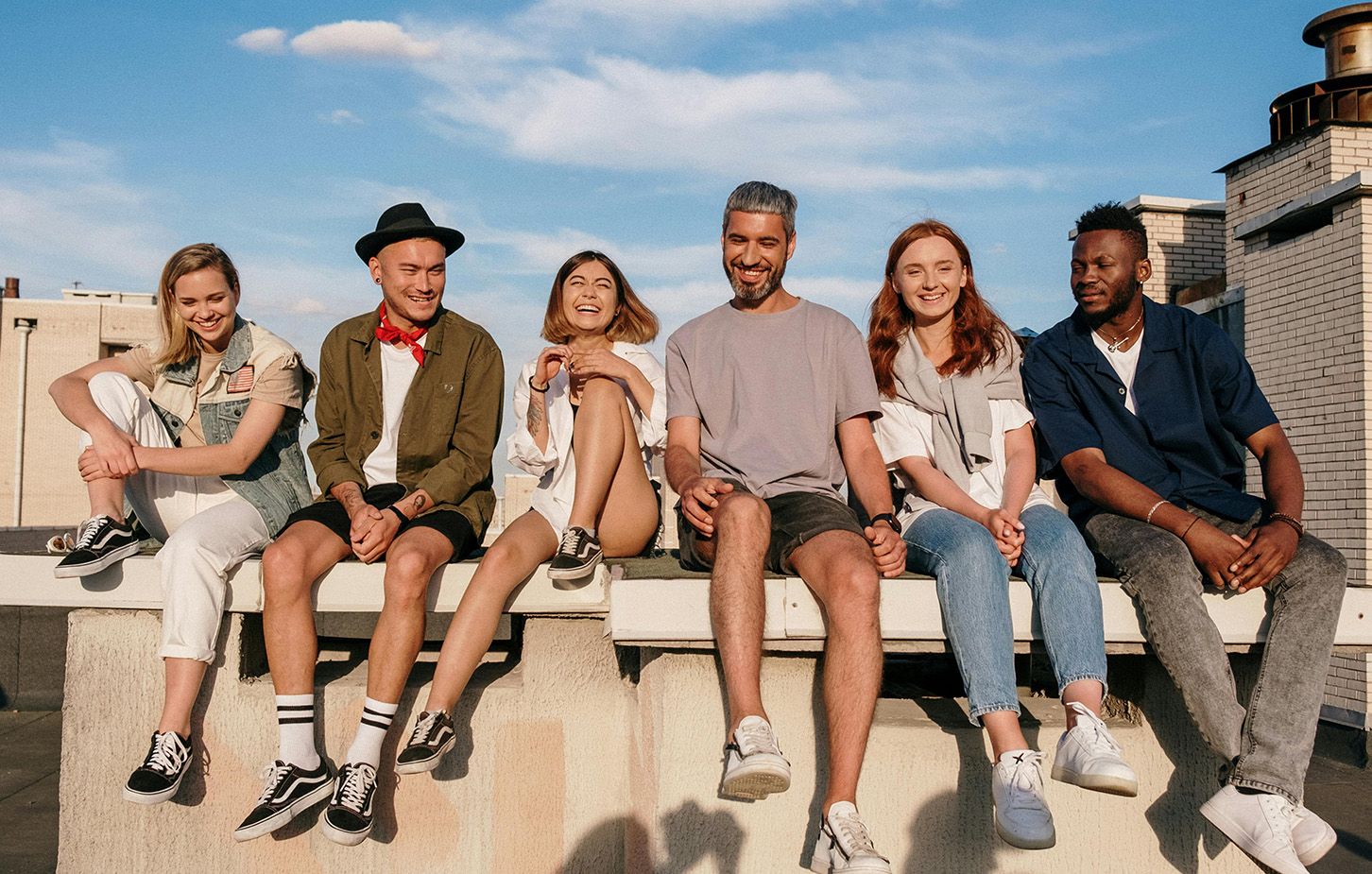 Gruppe junger Leute sitzt auf einer Mauer