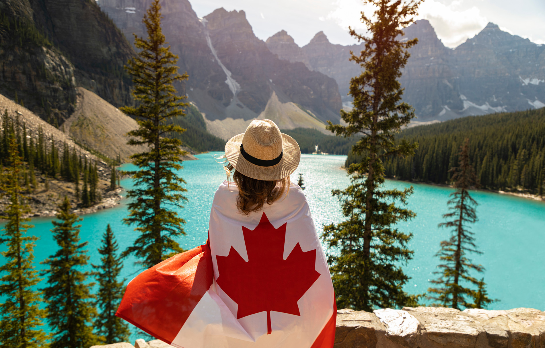Frau mit Kanada-Flagge steht vor einem See
