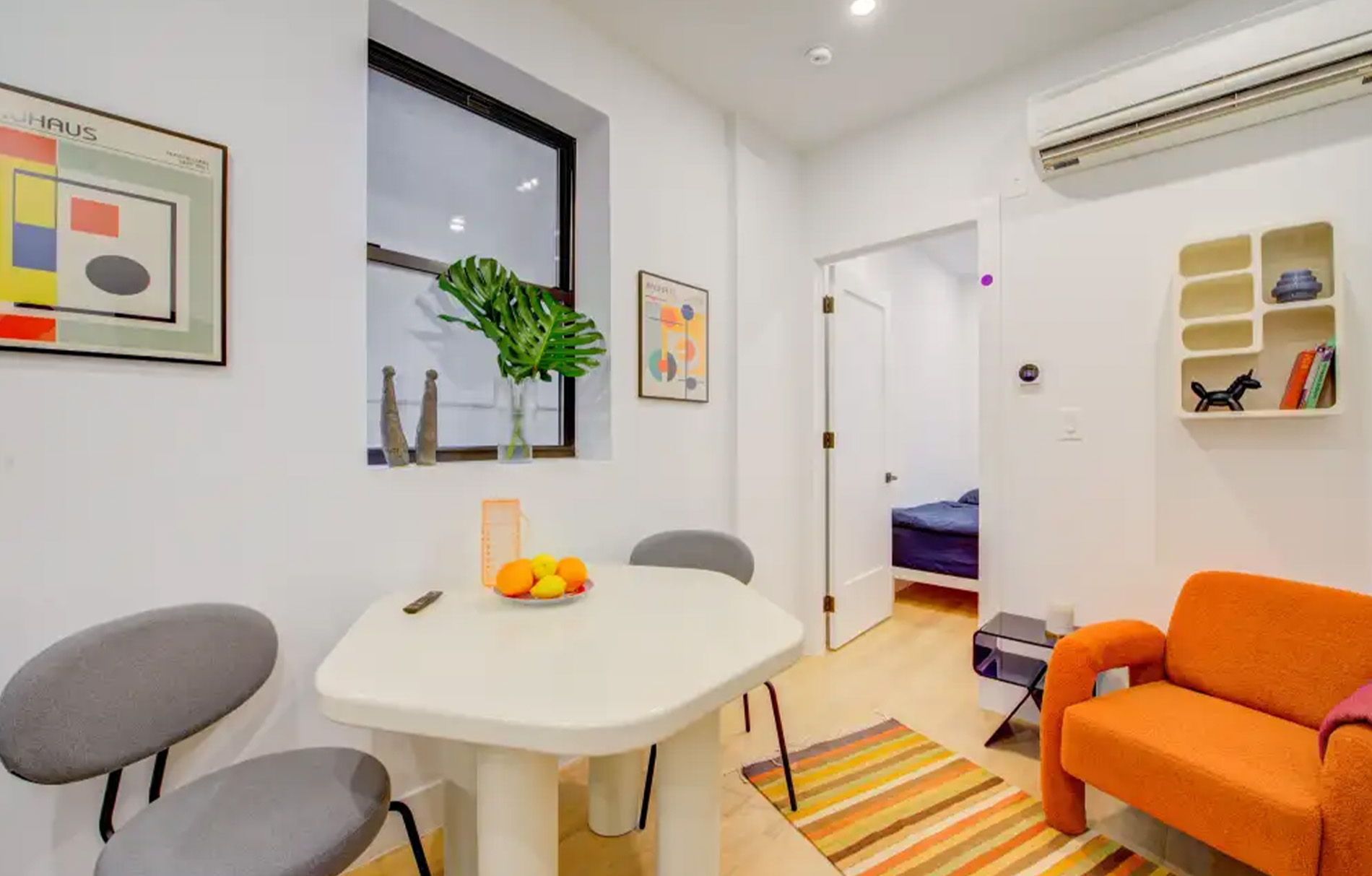 ein kleiner Tisch mit zwei Stühlen und einem orangen Sessel