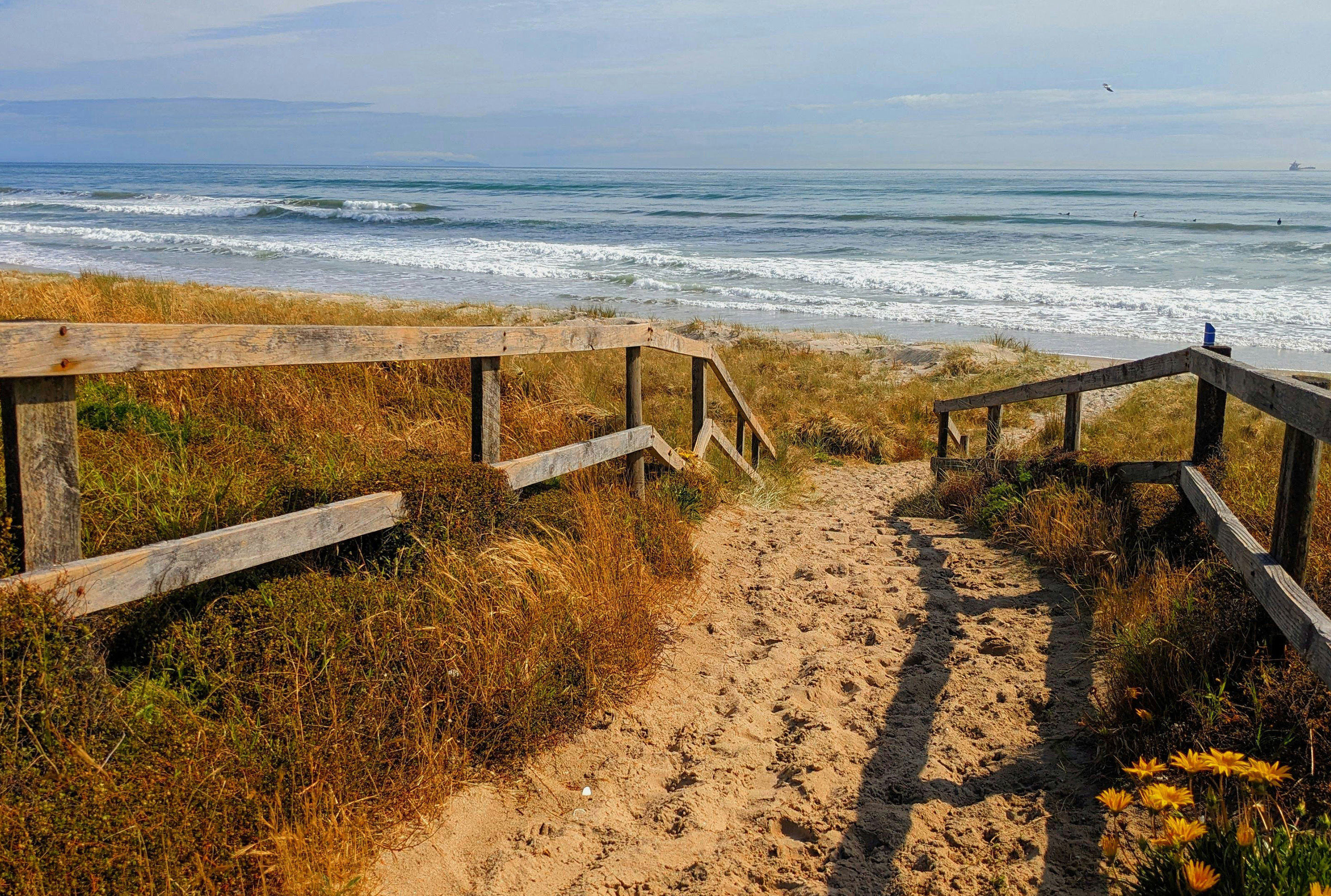 Weg durch die Düne zum Strand mit Blick aufs Meer