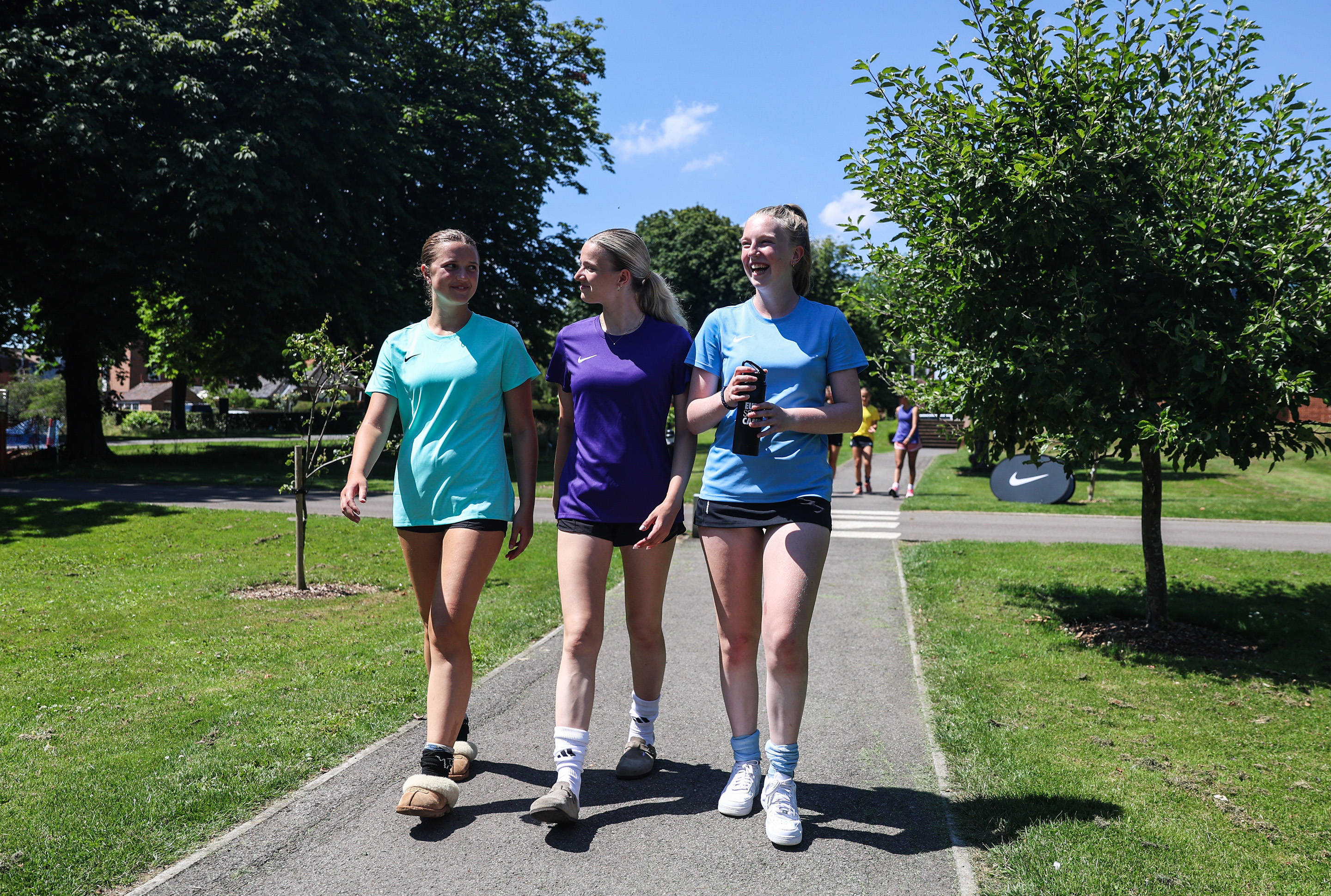 3 Mädchen in Sportoutfit laufen in Natur
